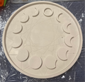 A round off-white silicone mold or tray with moon phases and a central star design.